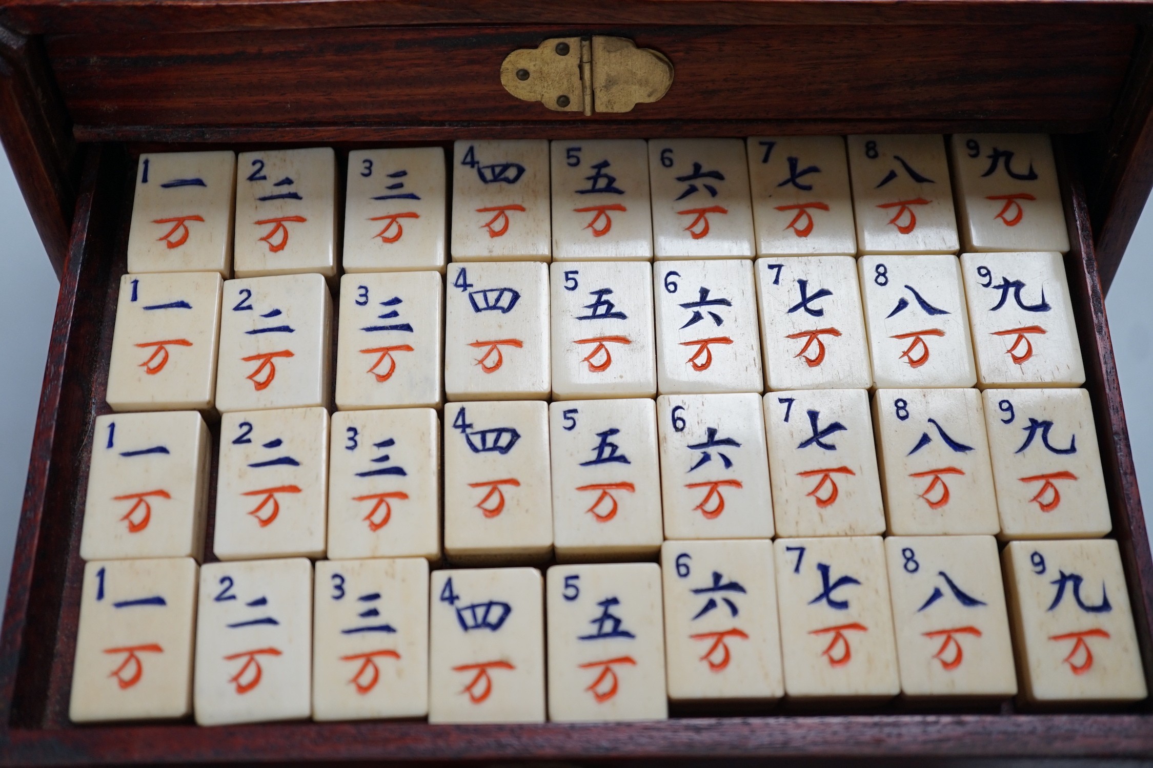 A Chinese Mah-Jong set in hardwood case with bone pieces